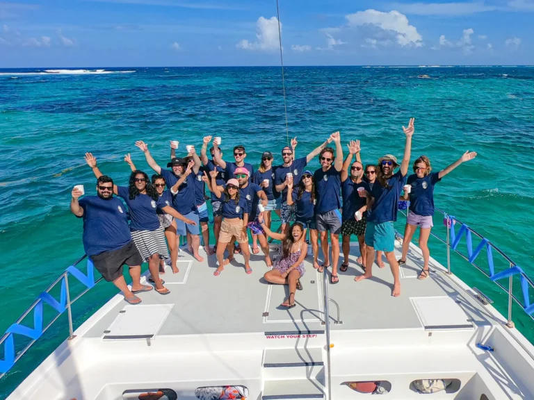 A company team in branded shirts on the bow of the catamaran