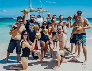 A group celebrating in the water beside the boat
