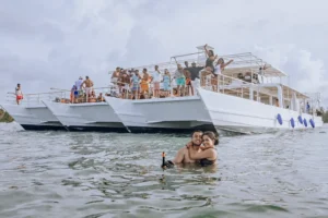 Guests in the water beside the Karaya with the upper deck full behind them