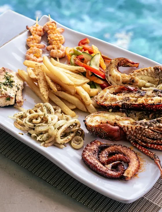 A plated grill of lobster, octopus, fish and fries served on board