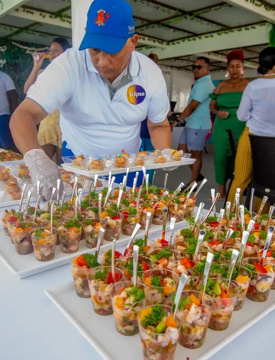 A Hispaniola chef serving gourmet appetizers to guests on deck
